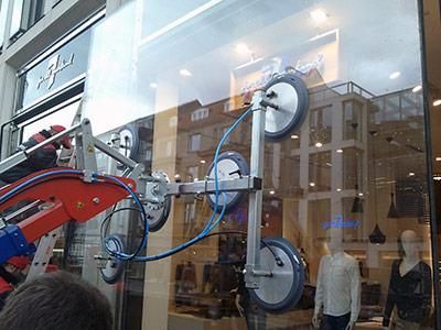 In einem Geschäft hebt eine Maschine ein Glasfenster an.