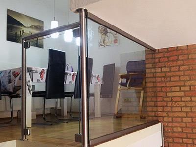 Ein Esszimmer mit einem Glasgeländer und einer Ziegelwand.