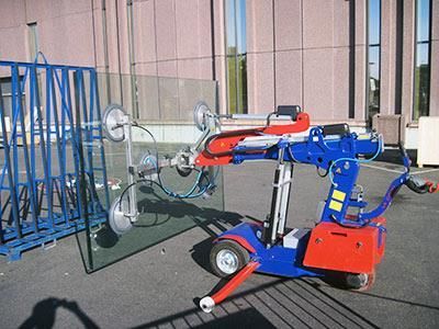 Eine blau-rote Maschine hebt ein großes Stück Glas