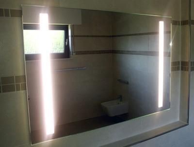 Ein Badezimmerspiegel mit zwei Lichtern darauf.