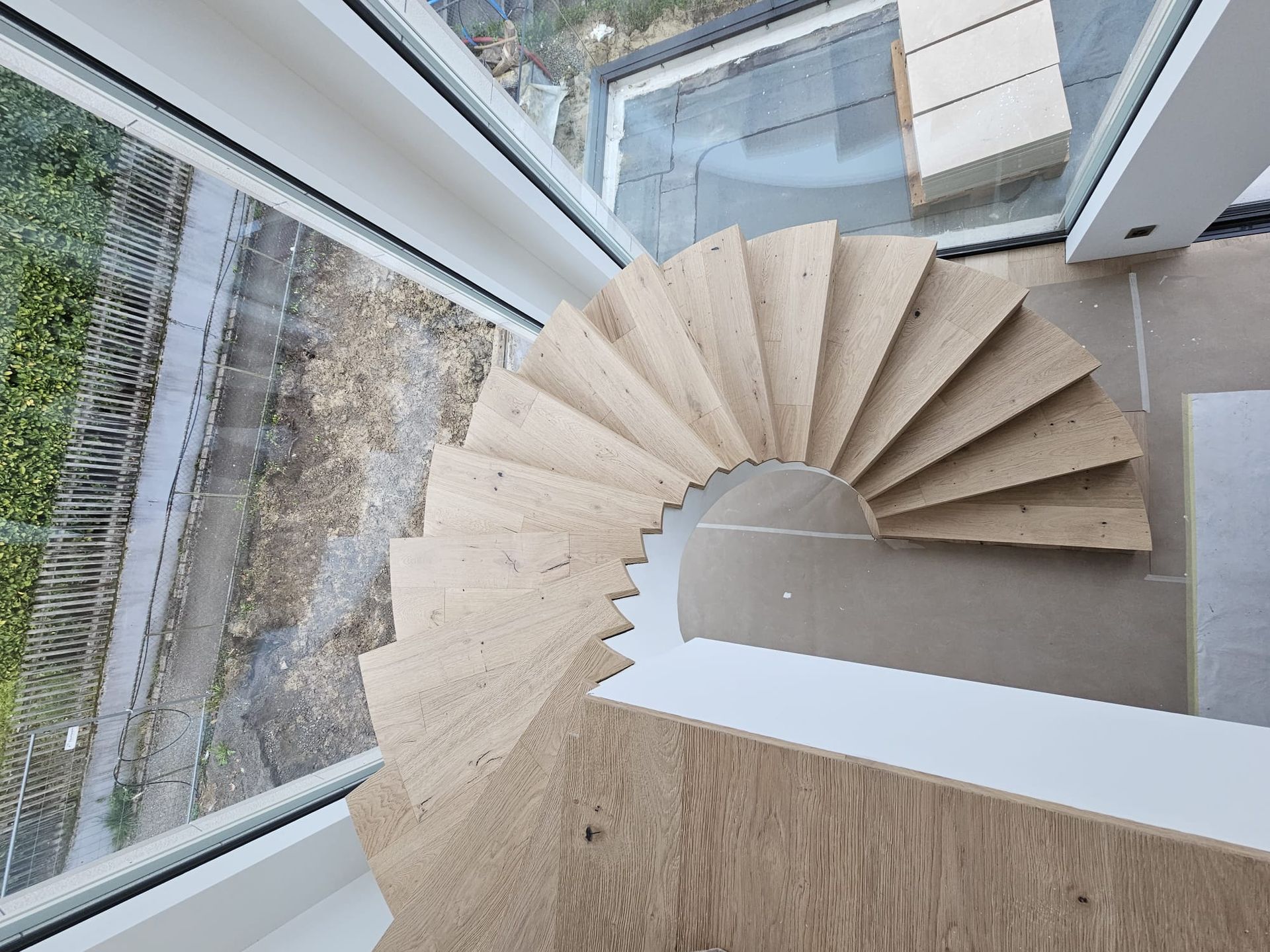 Ein Mann kniet nieder, um einen Holzboden zu verlegen.