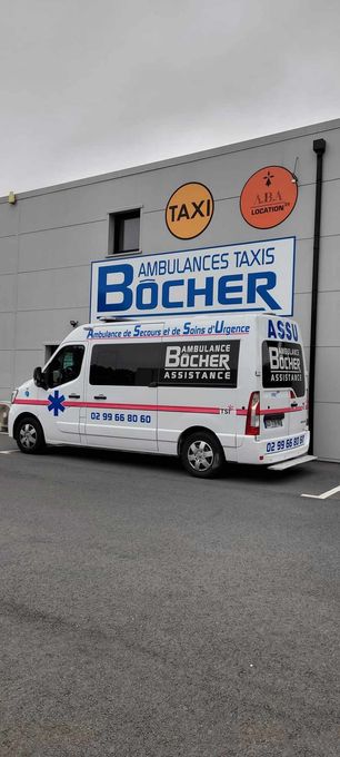 Ambulance blanche garée près d'un bâtiment avec de grandes enseignes de taxis
