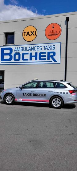 Un taxi argenté stationné près d'un bâtiment avec des panneaux Ambulances Taxis Bôcher sous un ciel bleu