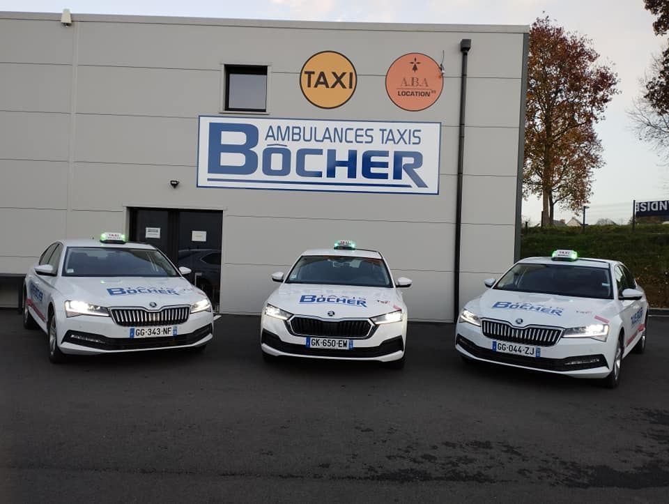 Trois taxis garés côte à côte devant une agence de l'entreprise Ambulances Taxis Bôcher