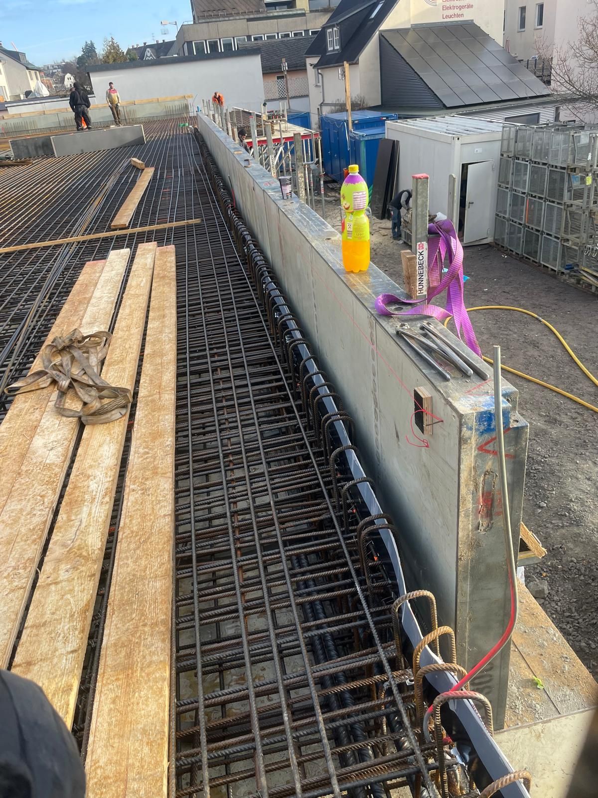 Baustelle mit Bewehrungsstahl, Betonschalungen und Baumaschinen.