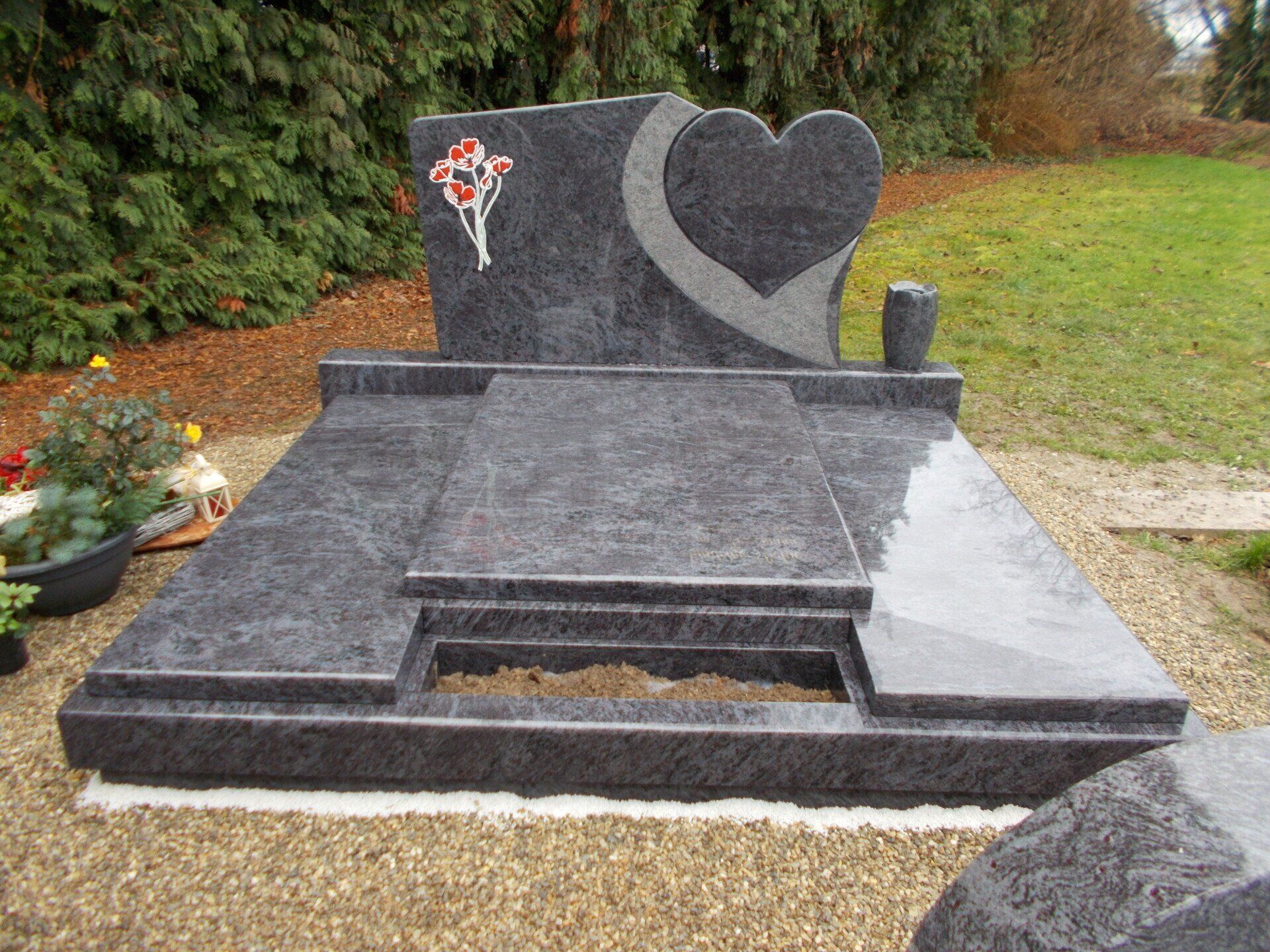 Pierre tombale avec un cœur et coquelicots