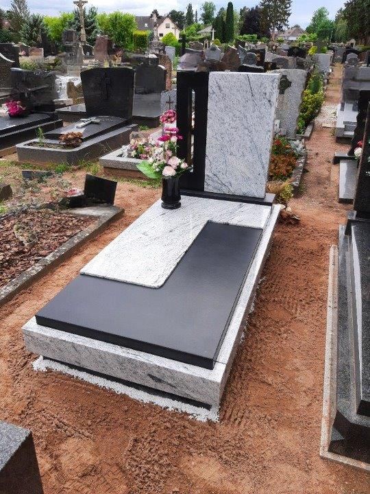 Une pierre tombale en marbre avec un bouquet de fleurs dessus