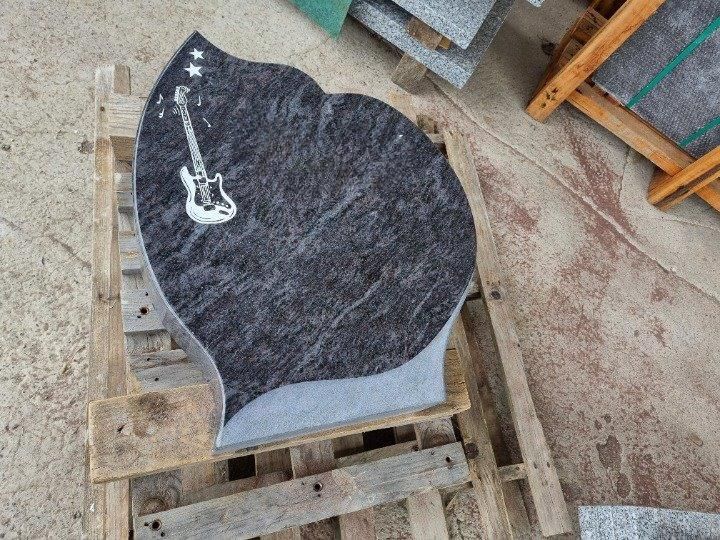 Un ornement en marbre avec une guitare gravée dessus