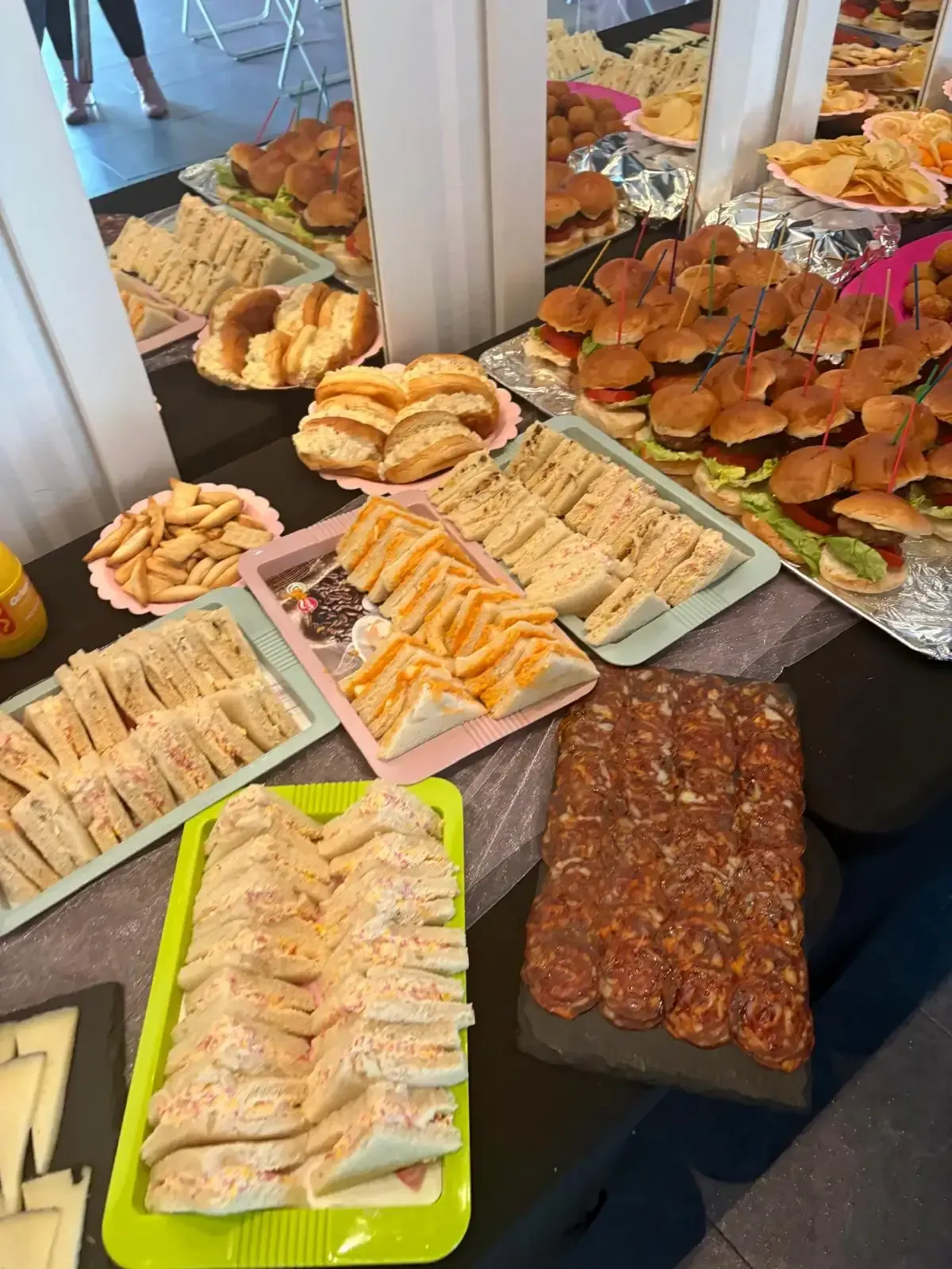 Variedad de pasteles y galletas horneadas expuestas en bandejas en el mostrador de una panadería.
