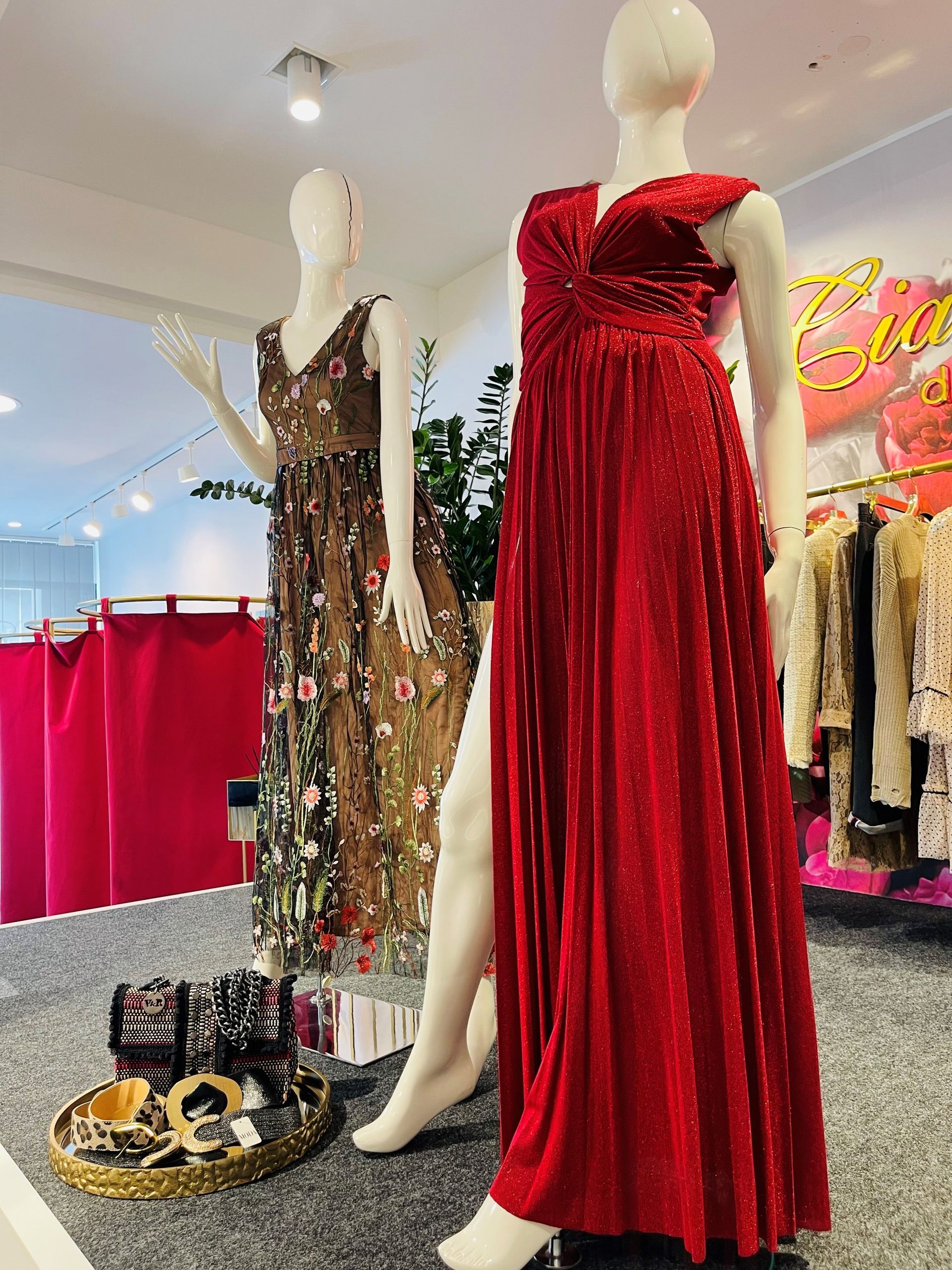 Eine Schaufensterpuppe mit einem roten Kleid steht neben einer Schaufensterpuppe mit einem braunen Kleid.