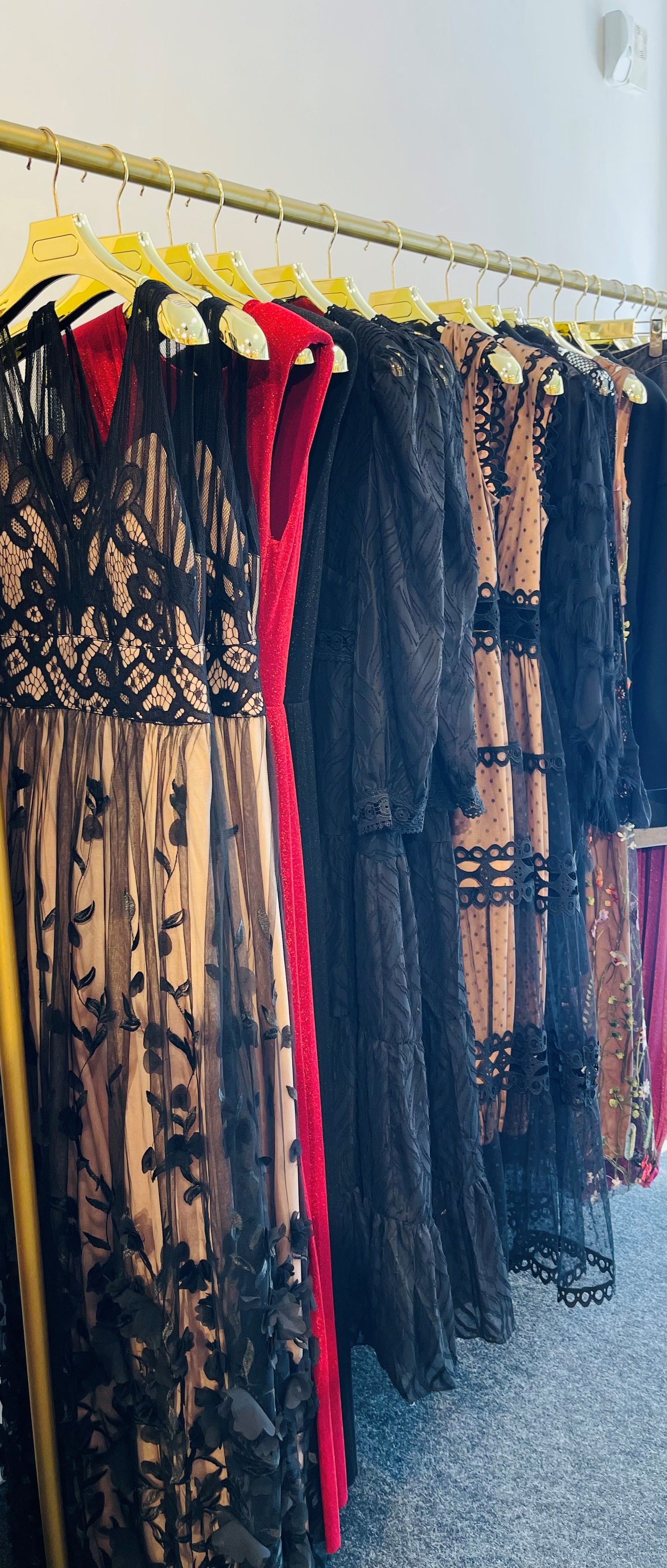 Eine Reihe von Kleidern hängt an einer Stange in einem Geschäft.