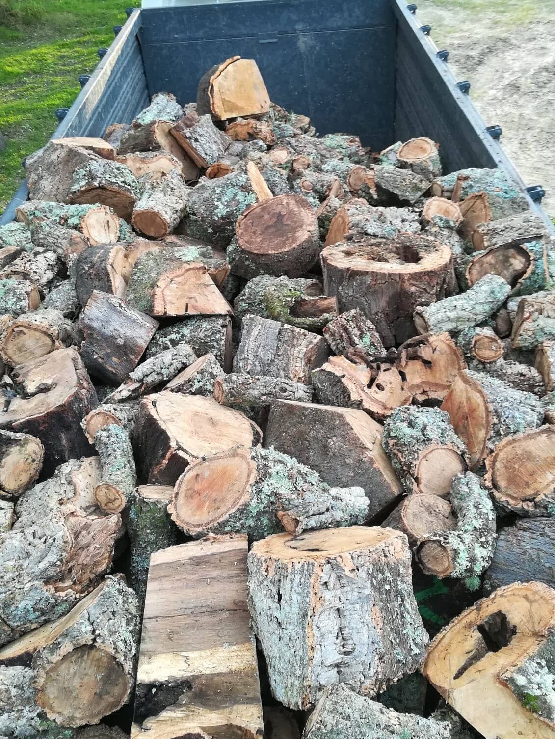 Pilha de lenha picada na carroceria de um caminhão.