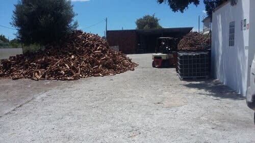 Pilha de madeira e estrutura com empilhadeira ao ar livre em um dia ensolarado.