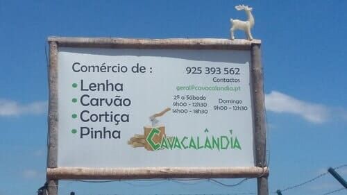 Placa da Cavalandia vendendo lenha, carvão, cortiça e pinhas. Inclui número de telefone e horário de funcionamento