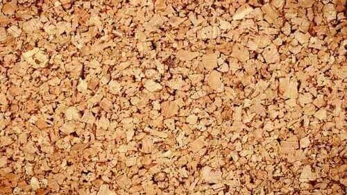 Detalhe da textura da cortiça em tons de marrom, com formas irregulares e superfície áspera.