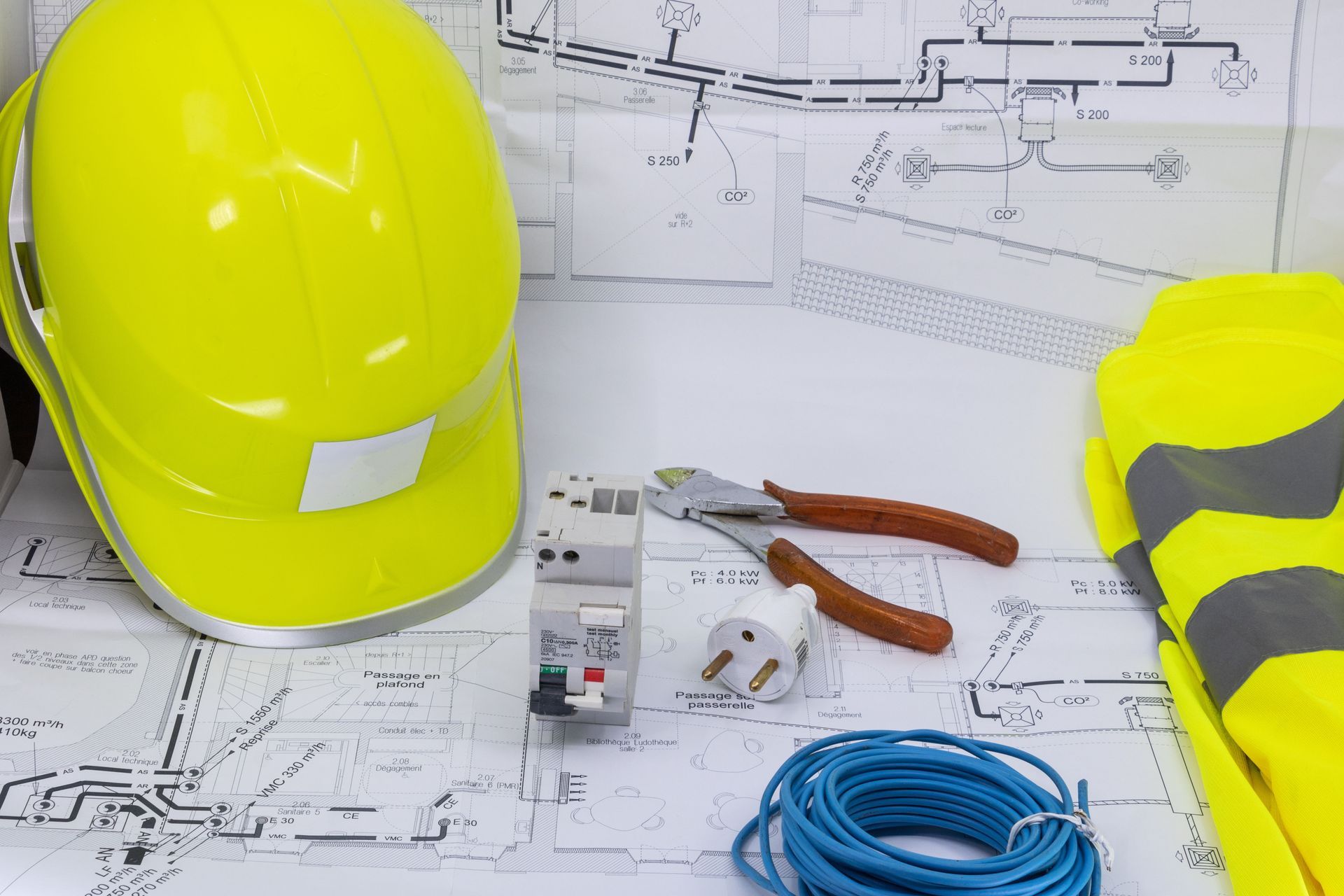 Équipements de sécurité, outils électriques, disjoncteur et bobine de fil disposés sur des schémas électriques.