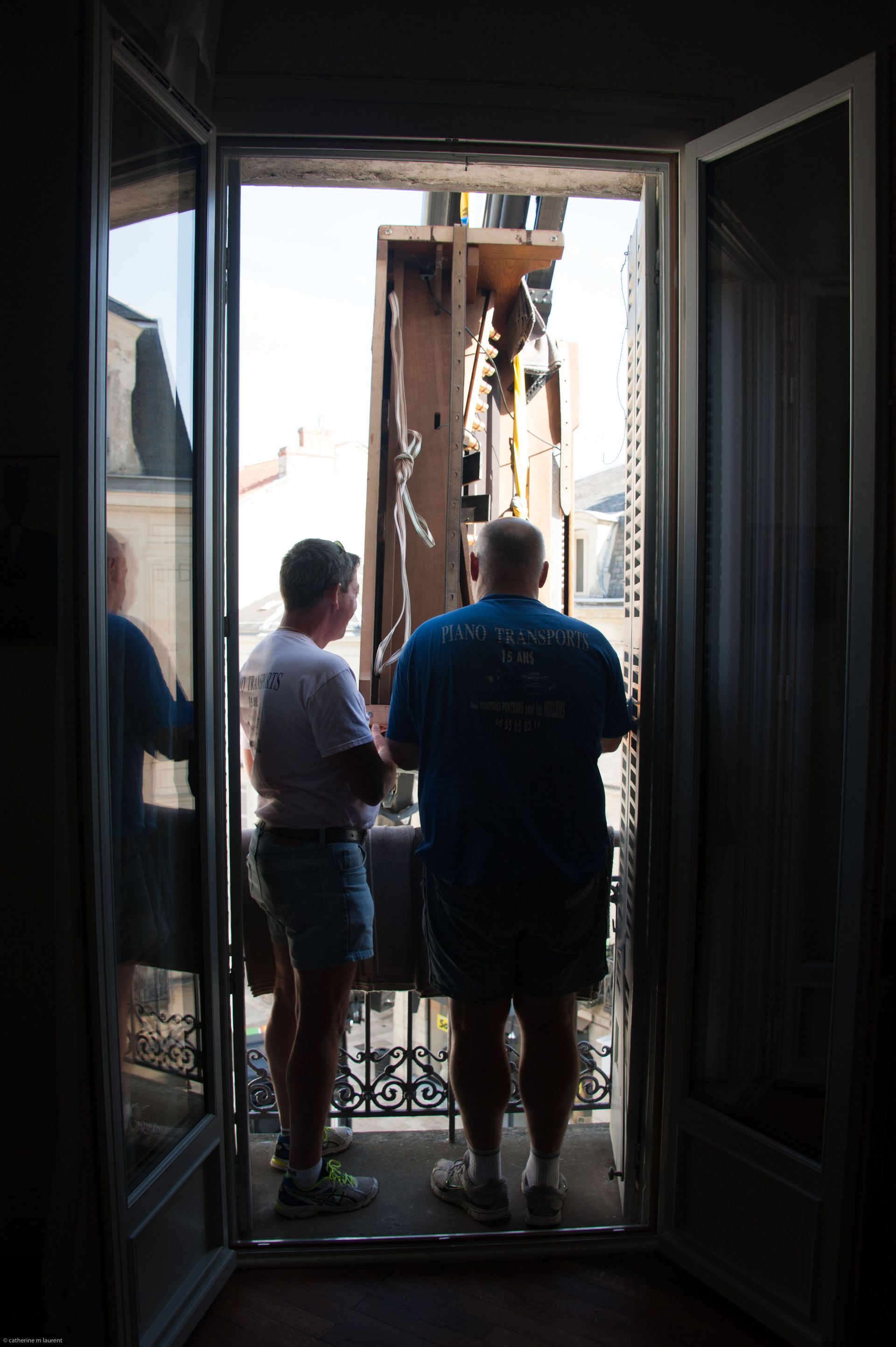Deux personnes se tiennent dans l'embrasure d'une porte, regardant à l'extérieur la structure endommagée d'un bâtiment.