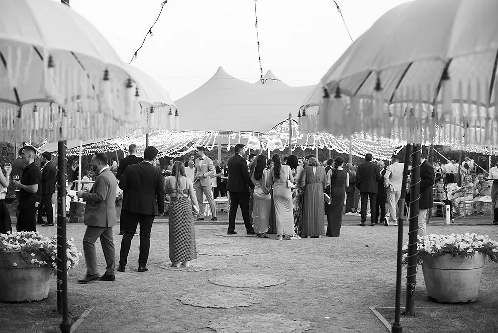 Una fotografía en blanco y negro de un grupo de personas paradas bajo paraguas.