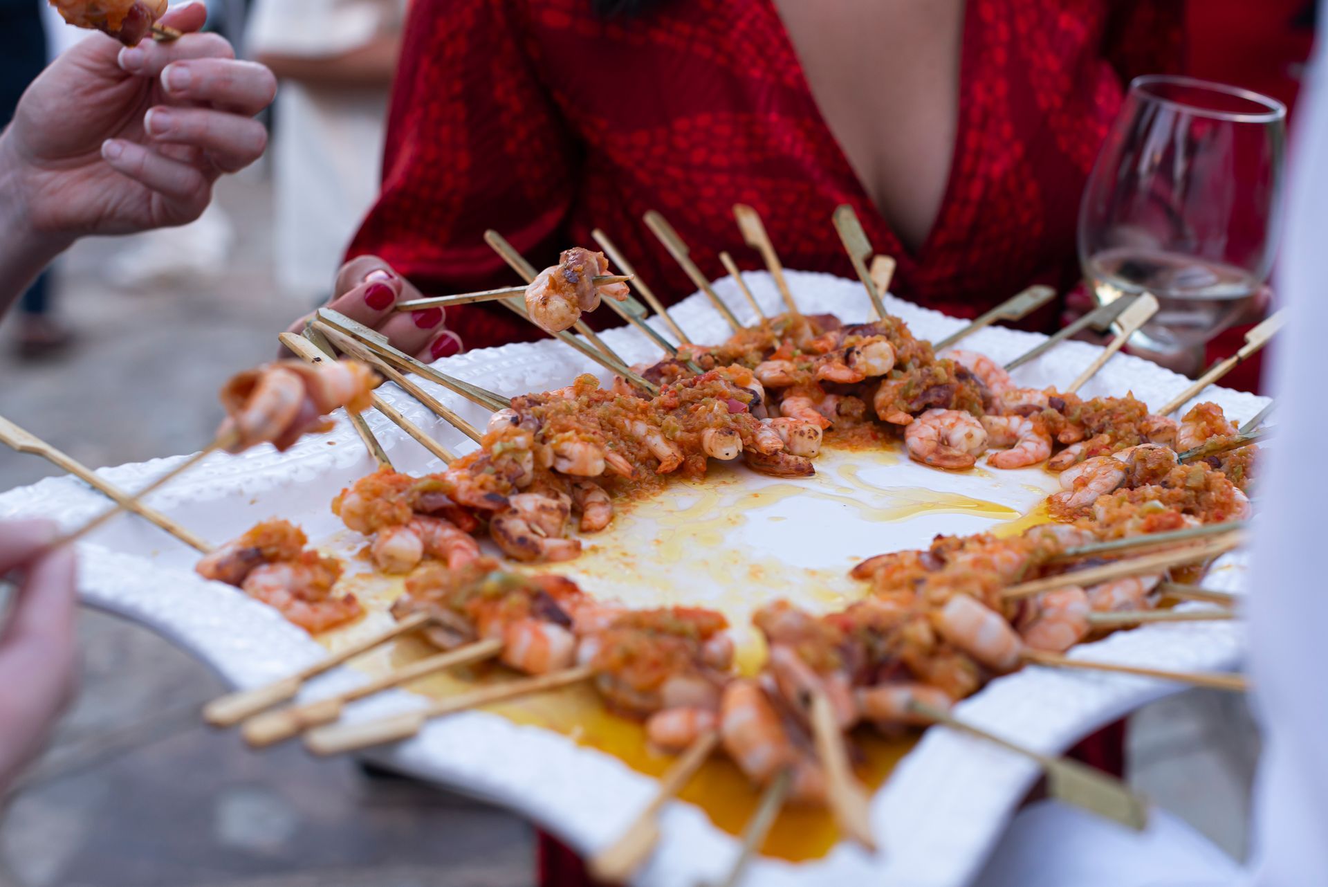 Una mujer está alcanzando un montón de hamburguesas de una mesa.