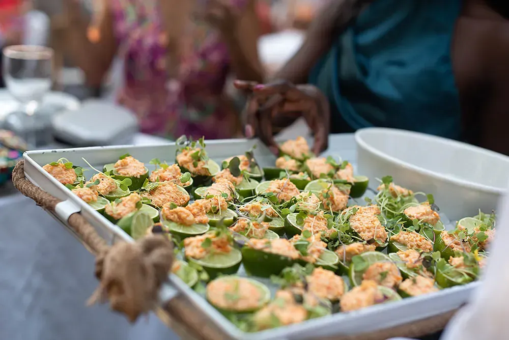 Una persona sostiene una bandeja de comida sobre una mesa.