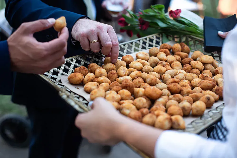 Un hombre sostiene una bandeja de comida y una mujer sostiene una bandeja de comida.