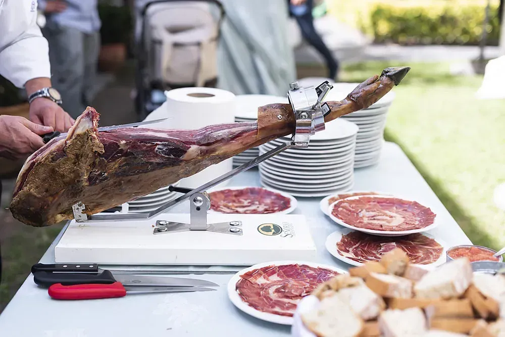Un hombre está cortando un trozo grande de carne en una tabla de cortar.