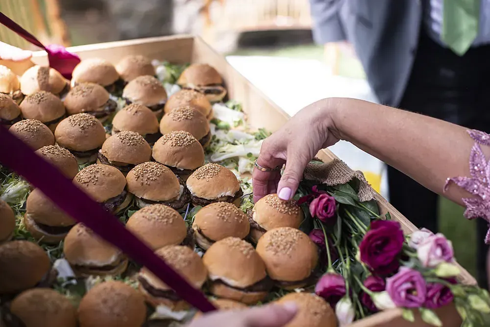 Una persona está cocinando carne en brochetas en una parrilla.