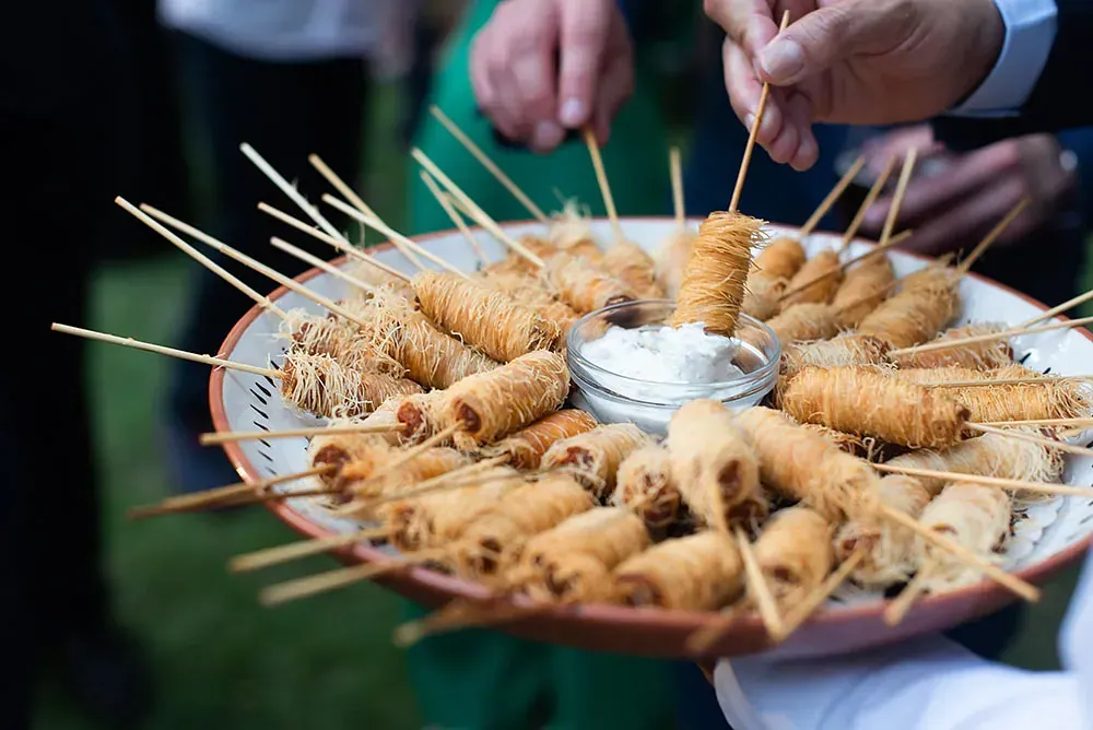 Una persona sostiene un plato de comida en palitos.