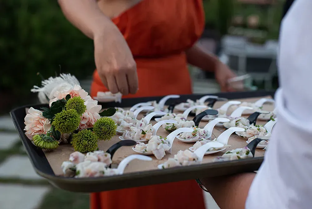 Una mujer sostiene una bandeja de flores y cucharas.