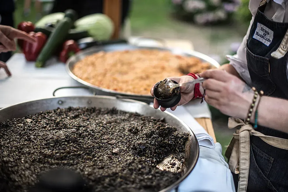 Una persona está cocinando comida en una sartén sobre una mesa.