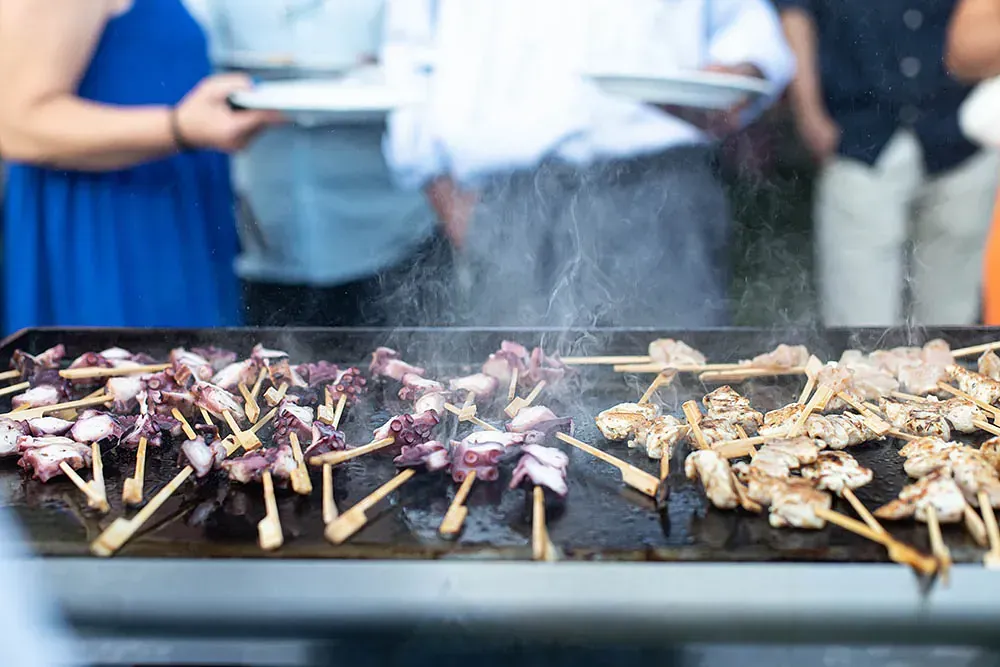 Un camarero lleva platos de comida en una bandeja.