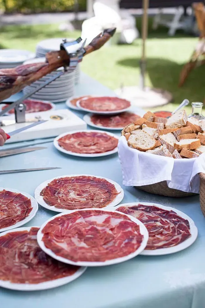 Una mesa cubierta con platos de carne y pan.