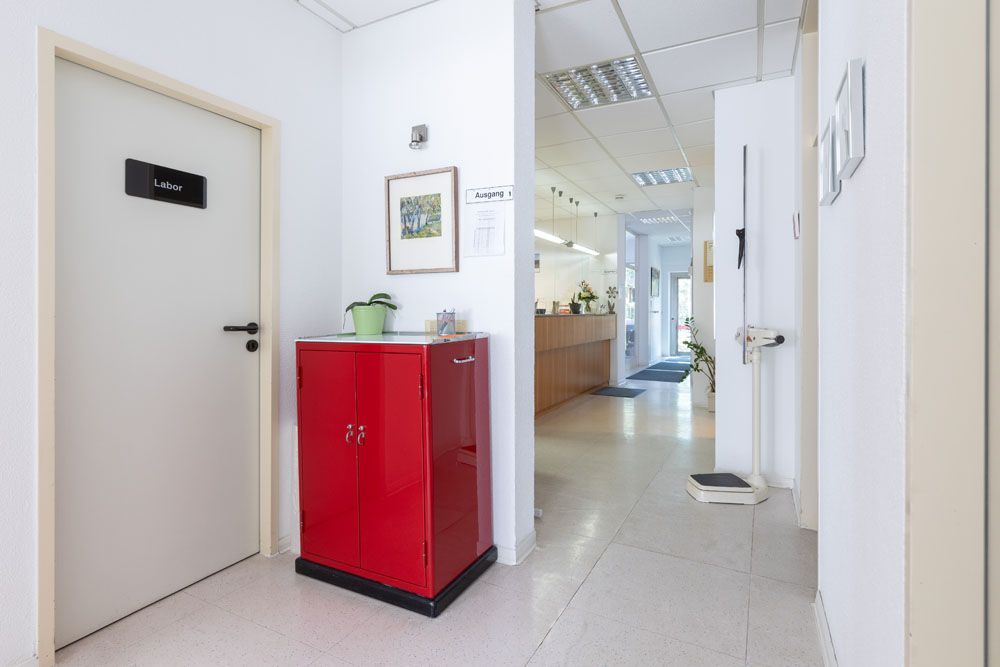 Ein roter Schrank steht in einem Flur neben einer Tür.