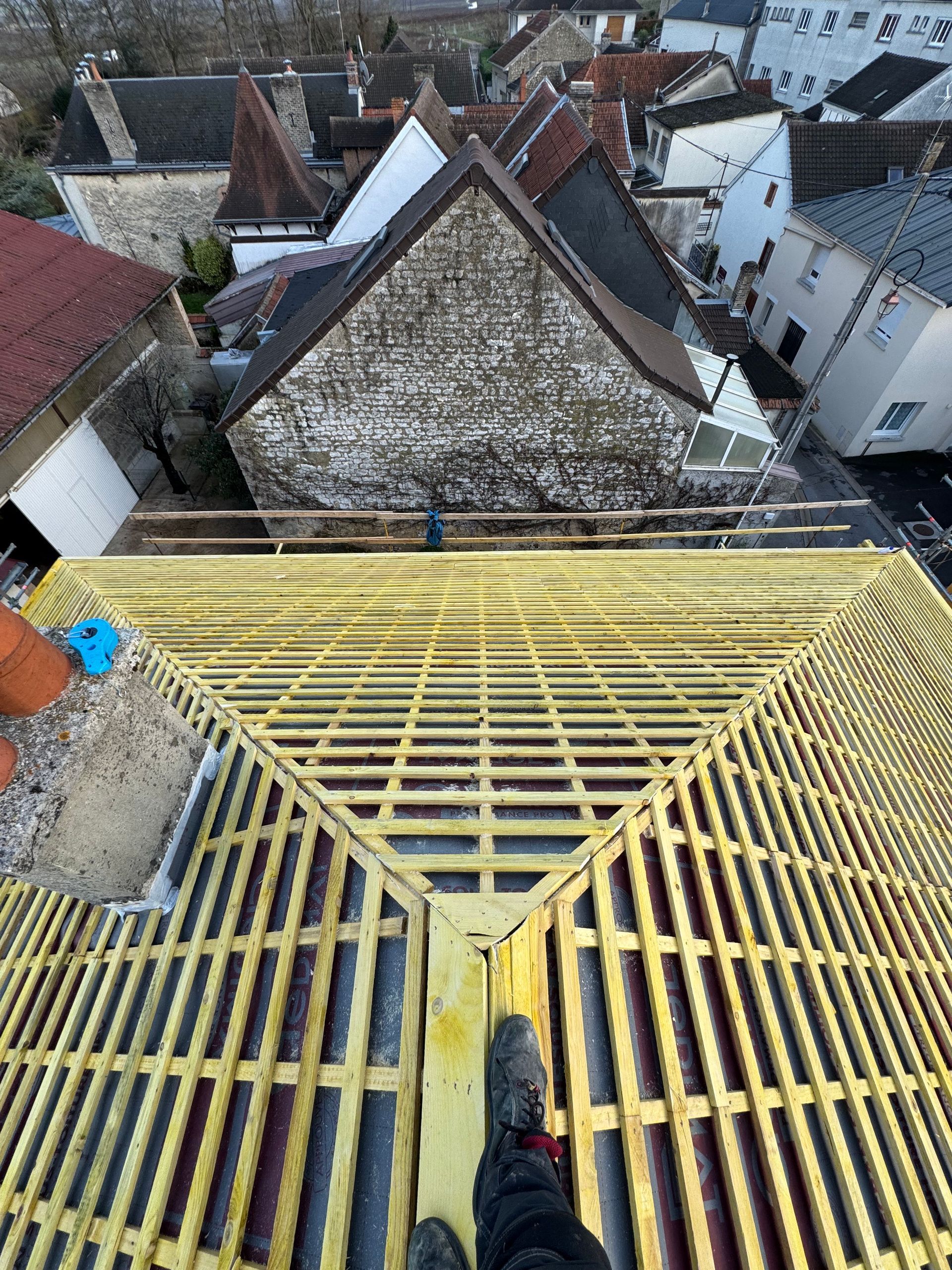 Une personne se tient sur le toit d'un bâtiment en construction.