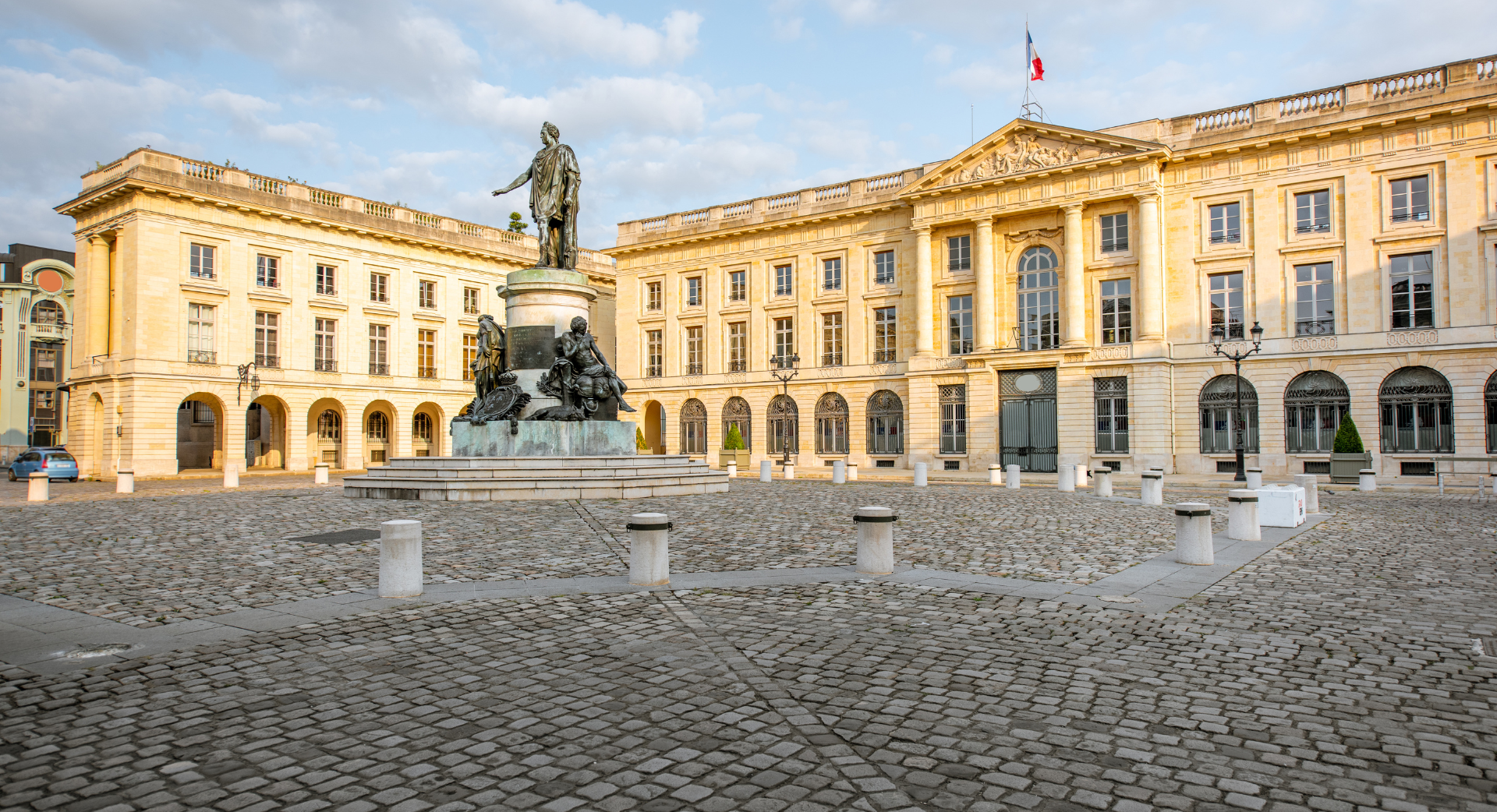 Un grand bâtiment avec une statue devant lui.