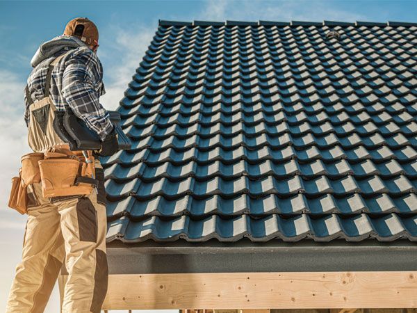 Un homme se tient debout sur un toit de tuiles.