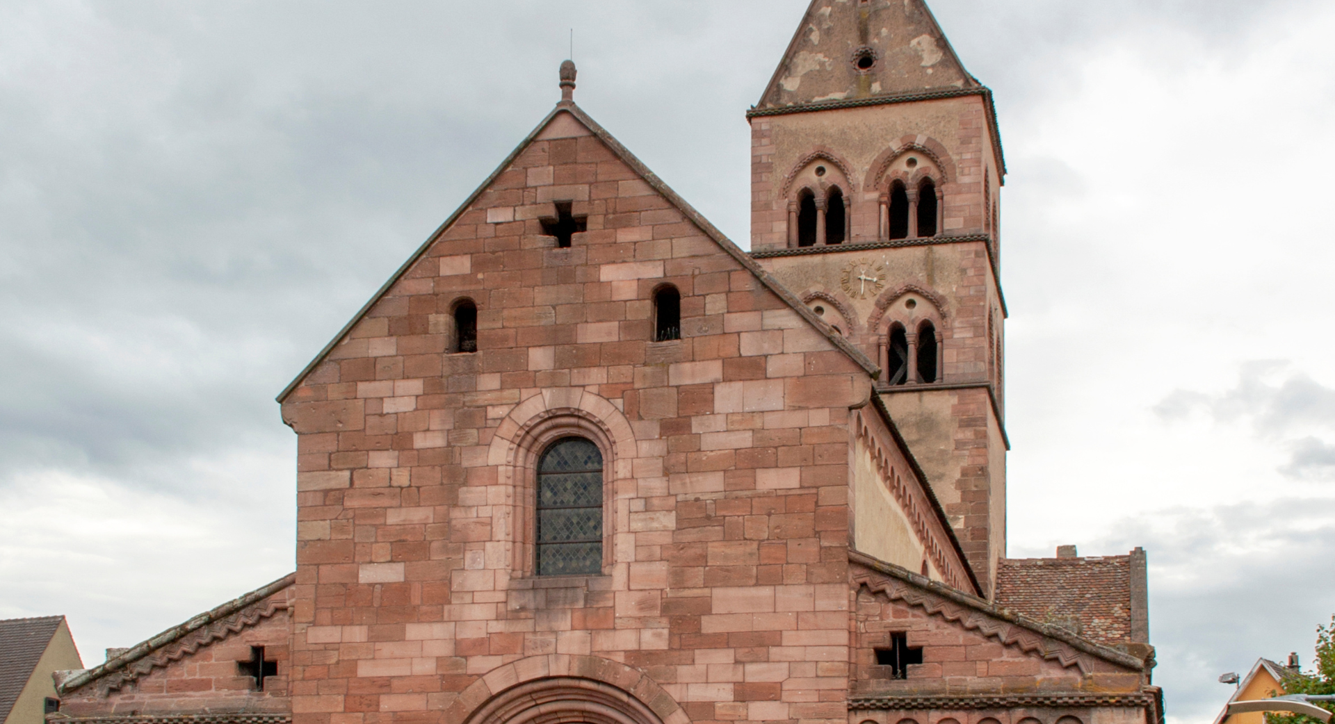 Une grande église en briques avec une tour au sommet.