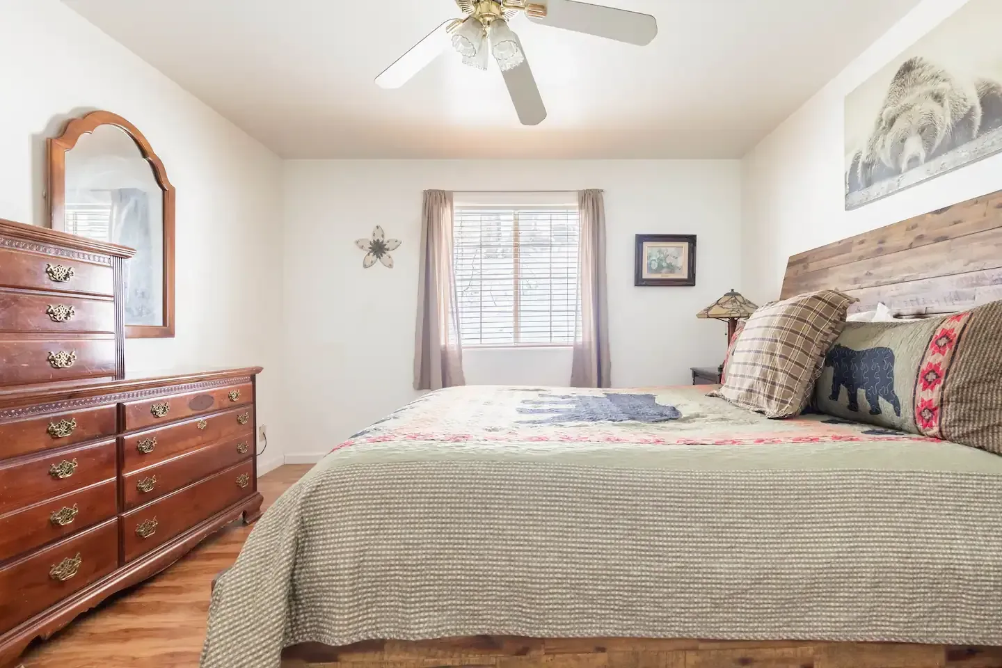 Bedroom with wooden bed, dresser, and bear-themed decor.