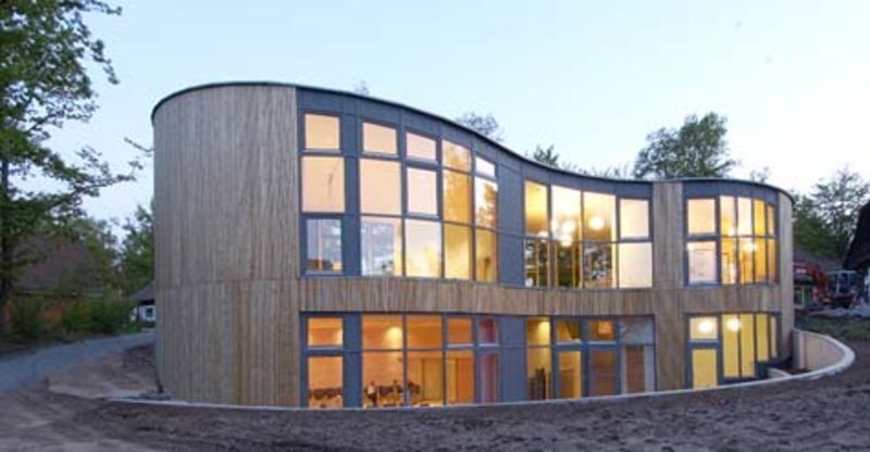 Une maison avec beaucoup de fenêtres et un toit incurvé