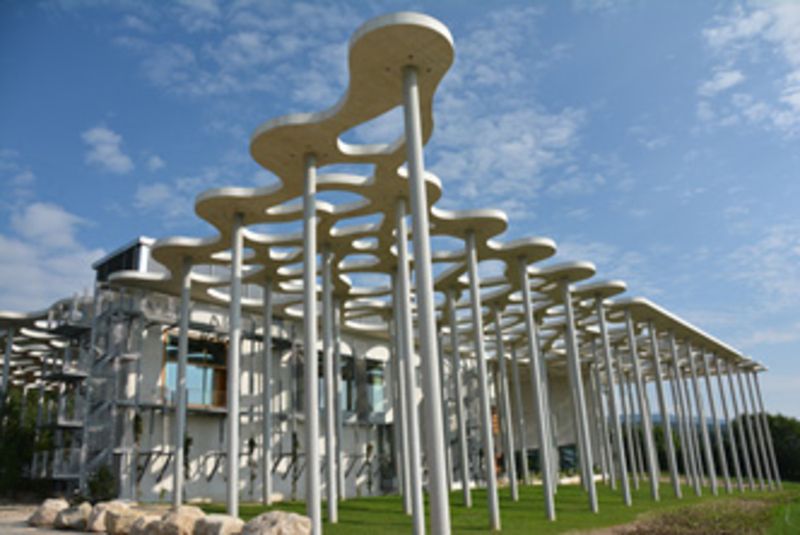 Un bâtiment avec beaucoup de poteaux devant