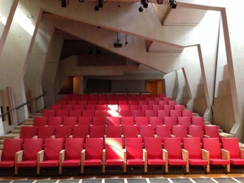 Rangées de chaises rouges dans un grand auditorium