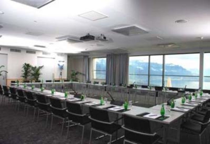 Une salle de conférence avec tables et chaises aménagées pour une réunion