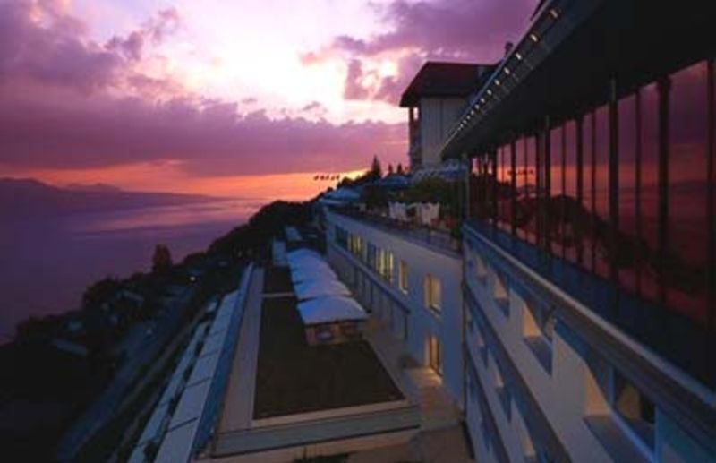 Un grand bâtiment avec un coucher de soleil en arrière-plan