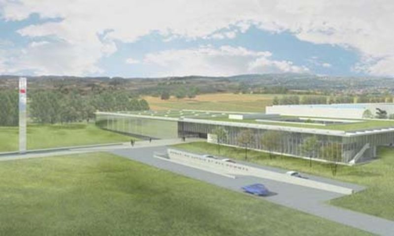 Vue d'artiste d'un grand bâtiment avec un toit vert au milieu d'un champ.