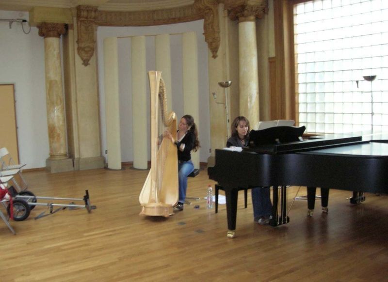 Une femme jouant de la harpe et une autre femme jouant du piano