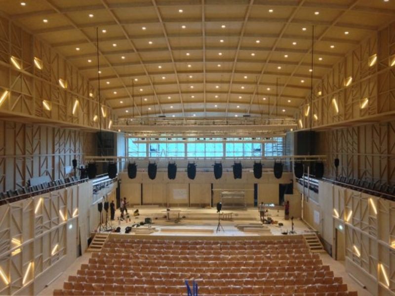 Un grand auditorium avec des sièges en bois et un plafond en bois