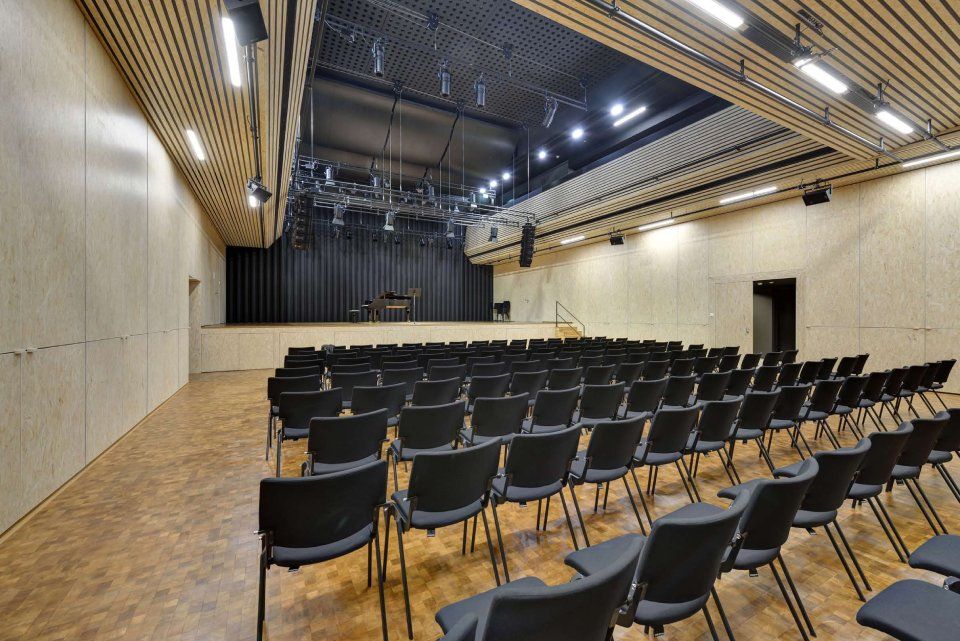 Un auditorium vide avec des sièges bleus et un grand écran