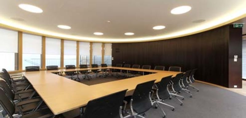 Une grande salle de conférence avec une longue table et des chaises.