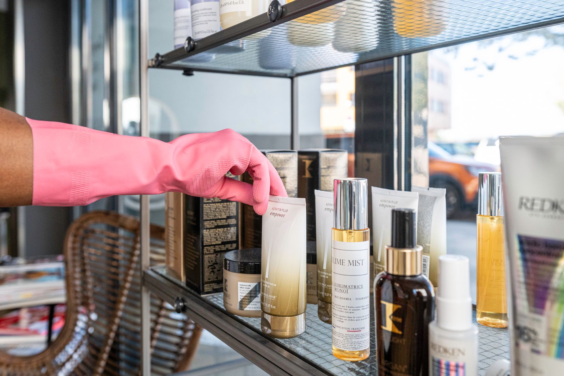 Nettoyage des produits de beauté sur une vitrine dans un salon de coiffure.