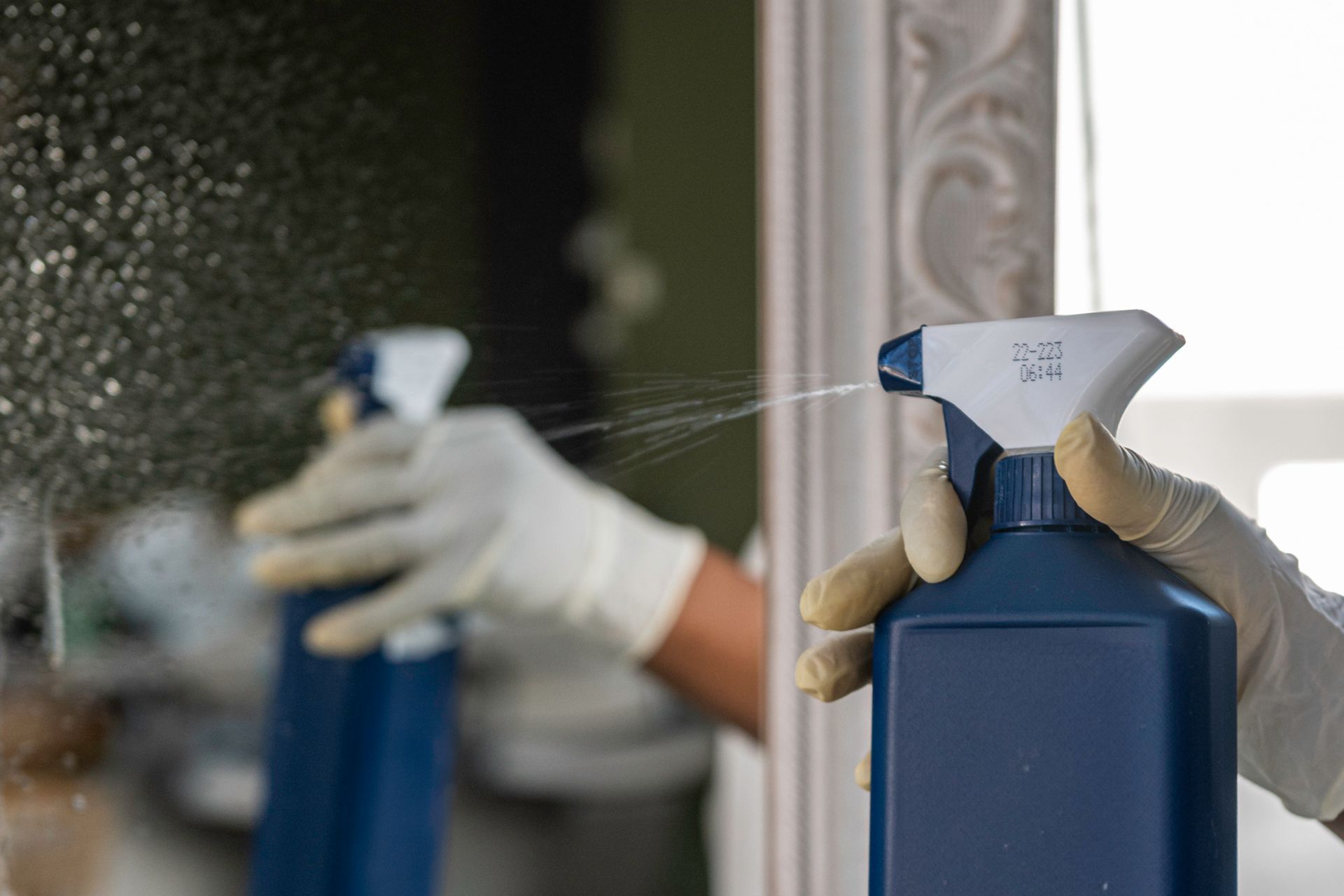 Nettoyage d'un miroir dans un salon de coiffure.
